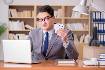 Businessman gambling playing cards at work