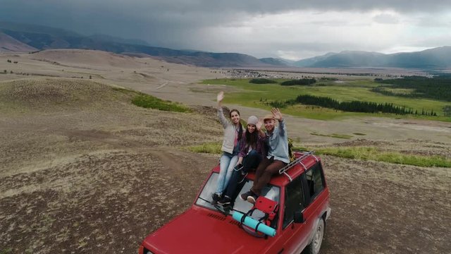 Couple On Road Trip Sit On Convertible Car Taking Selfie for drone 4k slow motion aerial shot.