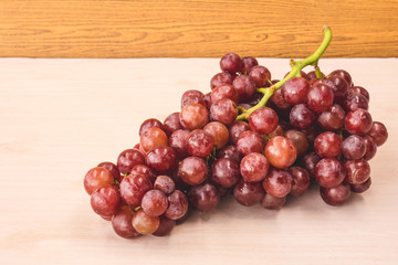 Red grapes on the wooden table.