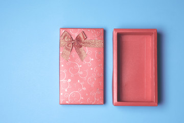 Top view of open red gift box on blue background. Free space for text