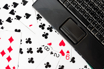 Close up of laptop keyboard on playing cards background.