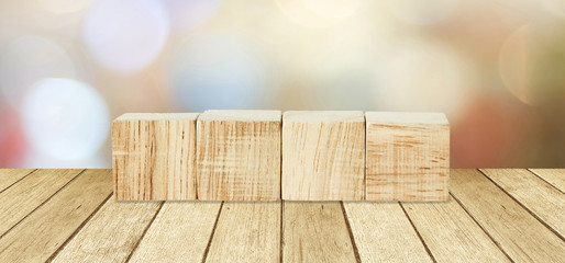 Four wooden cubes over perspective wood and blur abtract bokeh light background