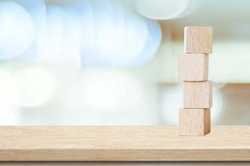 Four wooden cubes on table over blur abtract bokeh light background