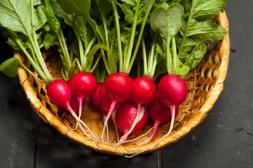Raw radish on a black wooden background