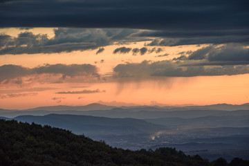 Powerful summer storm approaching the mountains in Sofia, Bulgaria under the beautiful golden light of the setting sun