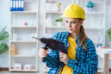 Woman in workshop with drilling drill