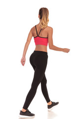 back view of a walking woman fitness instructor