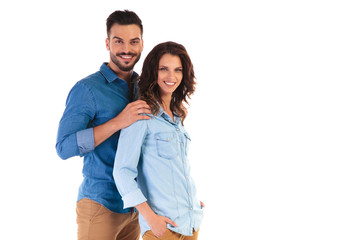 smiling casual man holding woman by shoulders