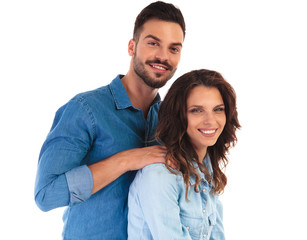 smiling casual man holding his woman by shoulders