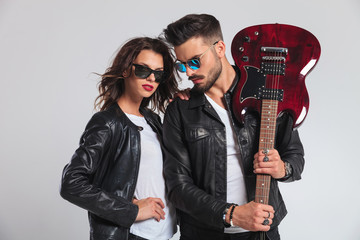 man showing his electric guitar with woman by his side