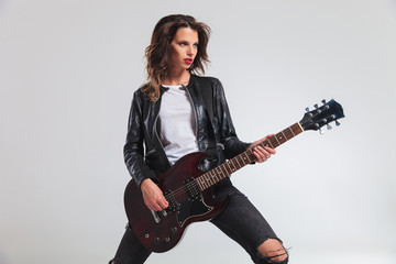 side view of a cool woman guitarist playing electric guitar