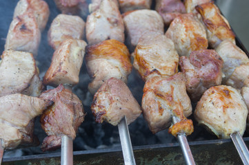 Pieces of juicy pork meat cooked outdoor on smouldering carbons