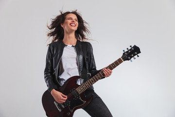 Obraz premium laughing woman guitarist enjoying herself while playing electric guitar