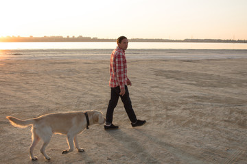 Young male having good time on mornink walk with dog 