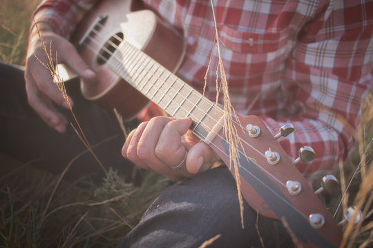 picture of young man ukulele player in the fields  
