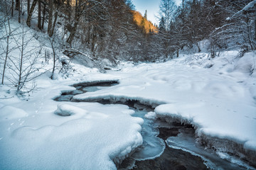Fototapeta na wymiar Mountain Carpathian river covered with snow