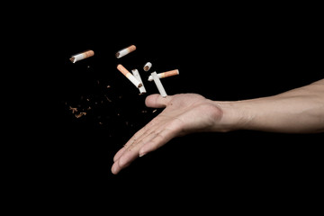 Hand throwing cigarette with motion freeze on black background , no smoke stop quitting sign