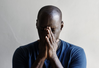 Black man with hands covered his face feeling worried - obrazy, fototapety, plakaty