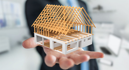 Businessman holding 3D rendering unfinished plan house in his hand