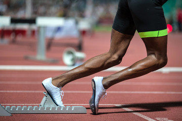 Male runner preparing for 400 m race at athletics meeting.