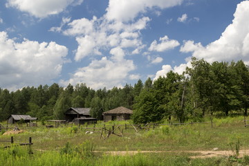 Old wooden houses on a rural landscape background
