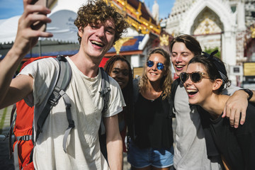 Group of diverse tourists taking selfie in Thai temple Thailand