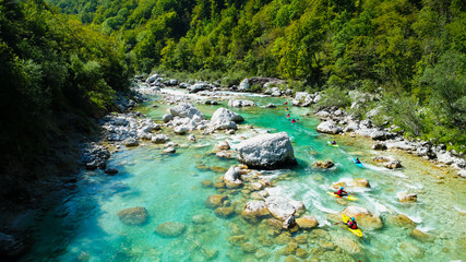 Emerald waters of Soca river, Slovenia, are the rafting paradise for adrenaline seekers and also nature lovers, aerial view.
