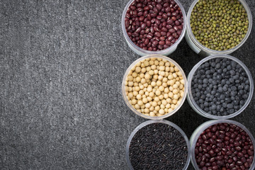 The ranks of different beans: soybean,  mung bean, bean, black bean. And black  rice. View from above. And copyspace.
