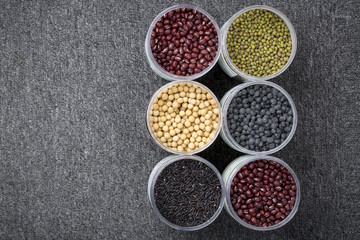 The ranks of different beans: soybean,  mung bean, bean, black bean. And black  rice. View from above. And copyspace.