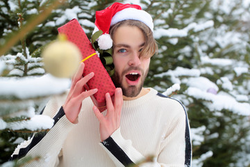 Surprised macho in red santa hat on winter day