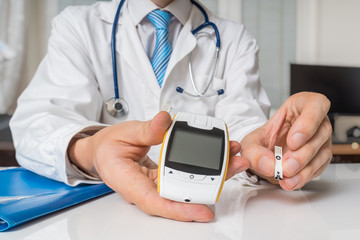 Doctor is giving glucometer to diabetic patient to measure blood sugar. Diabetes concept.