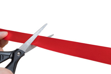 Scissors are cutting red ribbon or tape. Isolated on white background.