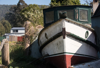 Fototapeta na wymiar Old wooden boat resting in front yard of house