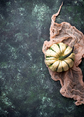 Decorative pumpkin on green concrete background