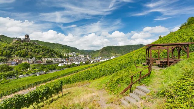 Summer vineyards timelapse at Moselle Valley with Cochem, Eifel in Germany in the background and the Reichsburg Cochem to the left. The wooden structure to the right is a lookout and resting place.