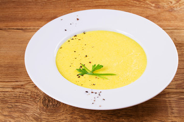 Cream corn soup in bowl on wooden background