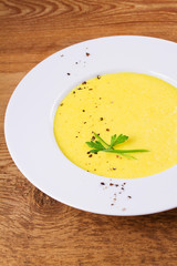 Cream corn soup in bowl on wooden background
