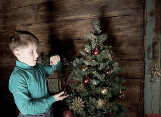 Happy little Boy decorate Christmas tree