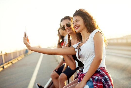 Young beautiful girls taking a selfie on the street.
