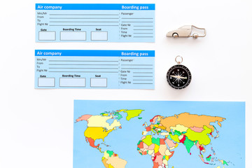 booking trip with map, tickets and tourist outfit on white office desk background top view