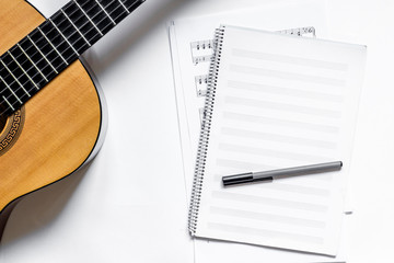musician work set with blank paper for notes and guitar white table background top view space for...
