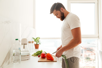 Side view of smiling bearded man with vegetable