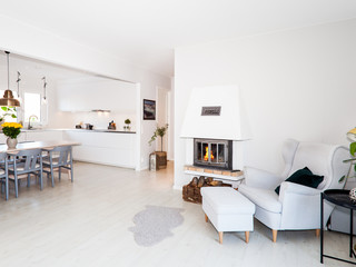 fireplace with a fire relaxing chair and the kitchen in the background