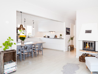 fancy apartment with lit fire i nthe fireplace and kitchen in teh background