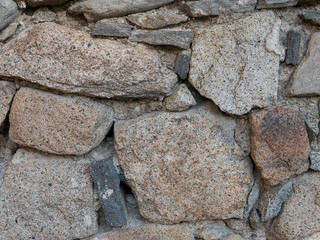 Natural stonewall texture for background. Stone wall built from stones and rocks of different sizes.