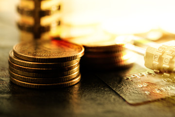 Double exposure of coins and credit card with combination lock on black granite background