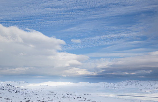 Frozen lake Vinstre and vast snow covered landscape with tiny red houses in Oppland, Norway