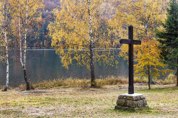 Big wooden cross at the lake in autumn