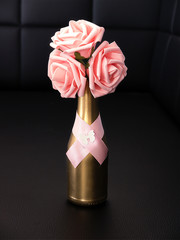 Pink roses in an golden bottle