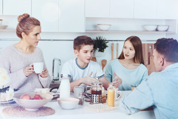Obraz na płótnie Canvas Four membered family chatting during breakfast